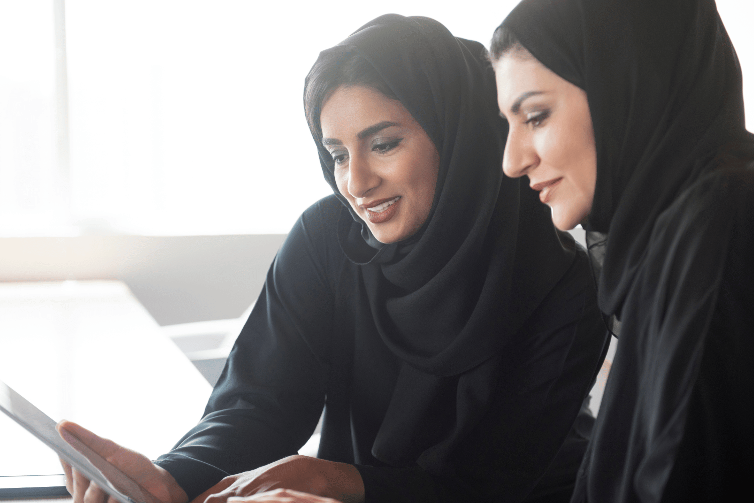 Saudi manager helping coach and mentor a fellow employee to help empower her